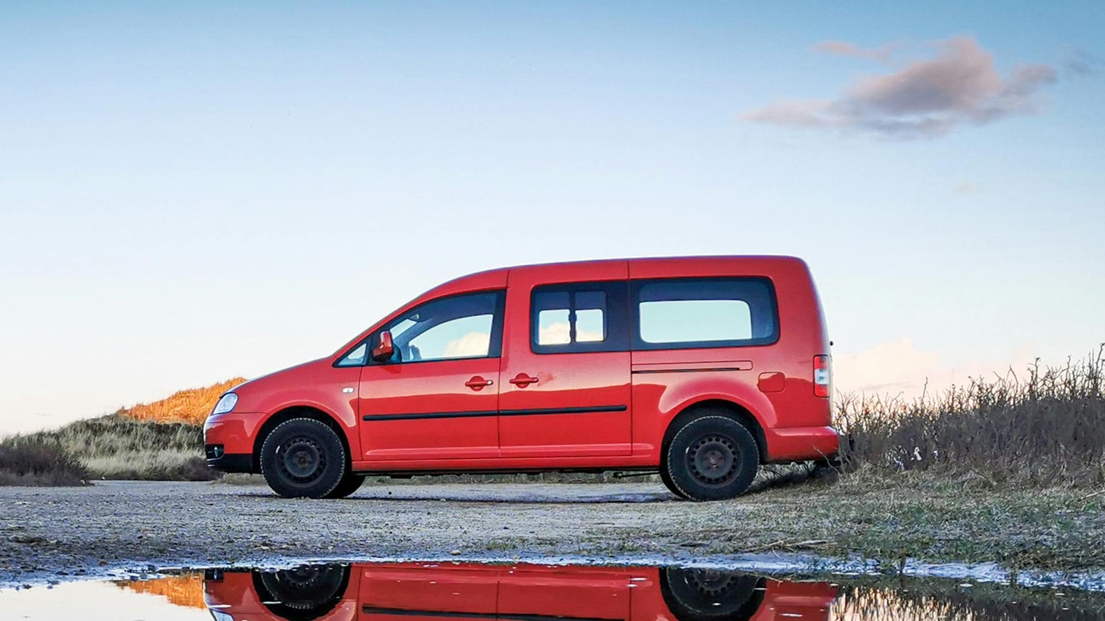 Rød bil ved vandpyt