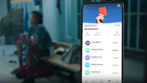 En mobiltelefon i forgrunden med skærmbillede fra Mobilepay Box og et omklædningsrum i baggrunden