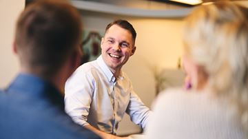 Mandlig medarbejder taler med nogle kolleger