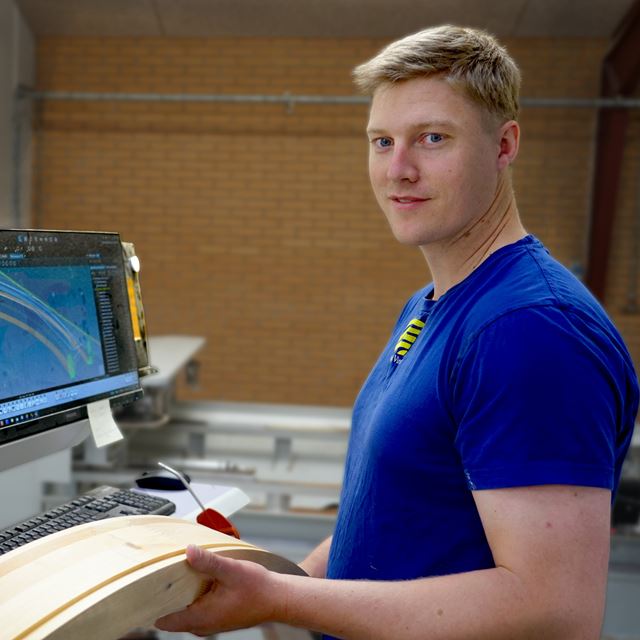 Medejer Frederik Holm Madsen med træ der er bearbejdet af de nye maskiner fra Italien